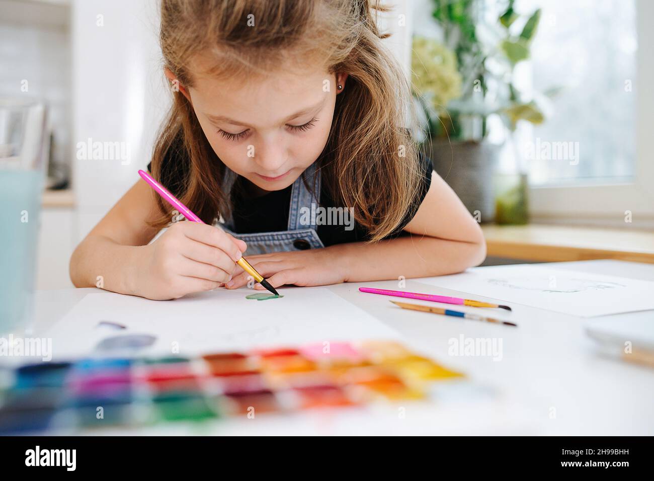 Close up low angle image of a little girl painting with watercolor ...