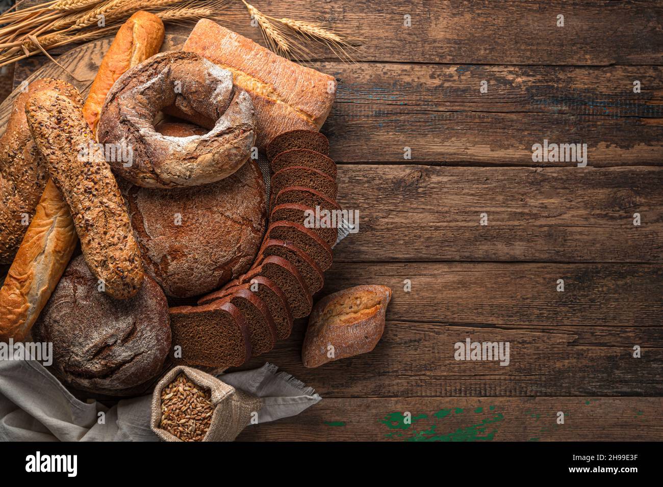 Freshly baked traditional bread of various types on a wooden table. Top view, copy space. Stock Photo