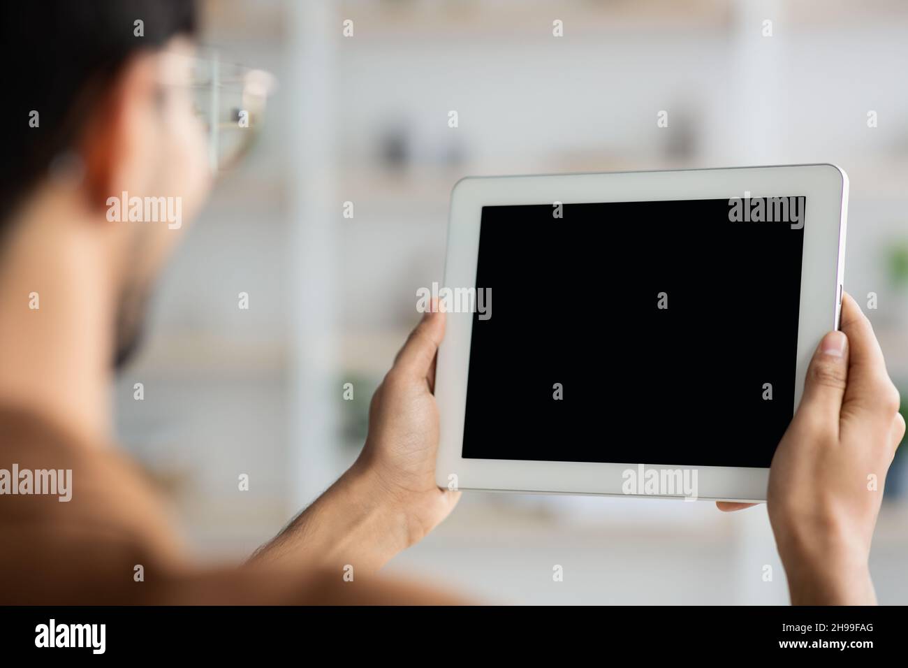 Unrecognizable young man holding digital tablet, mockup Stock Photo