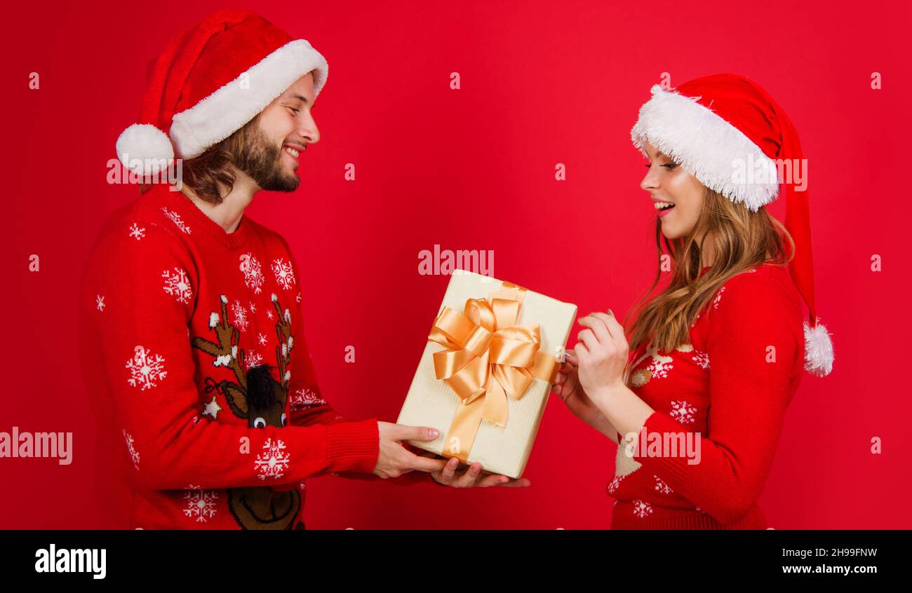Happy Santa couple in red sweater Christmas hat with present box. Happy New Year celebration Stock Photo