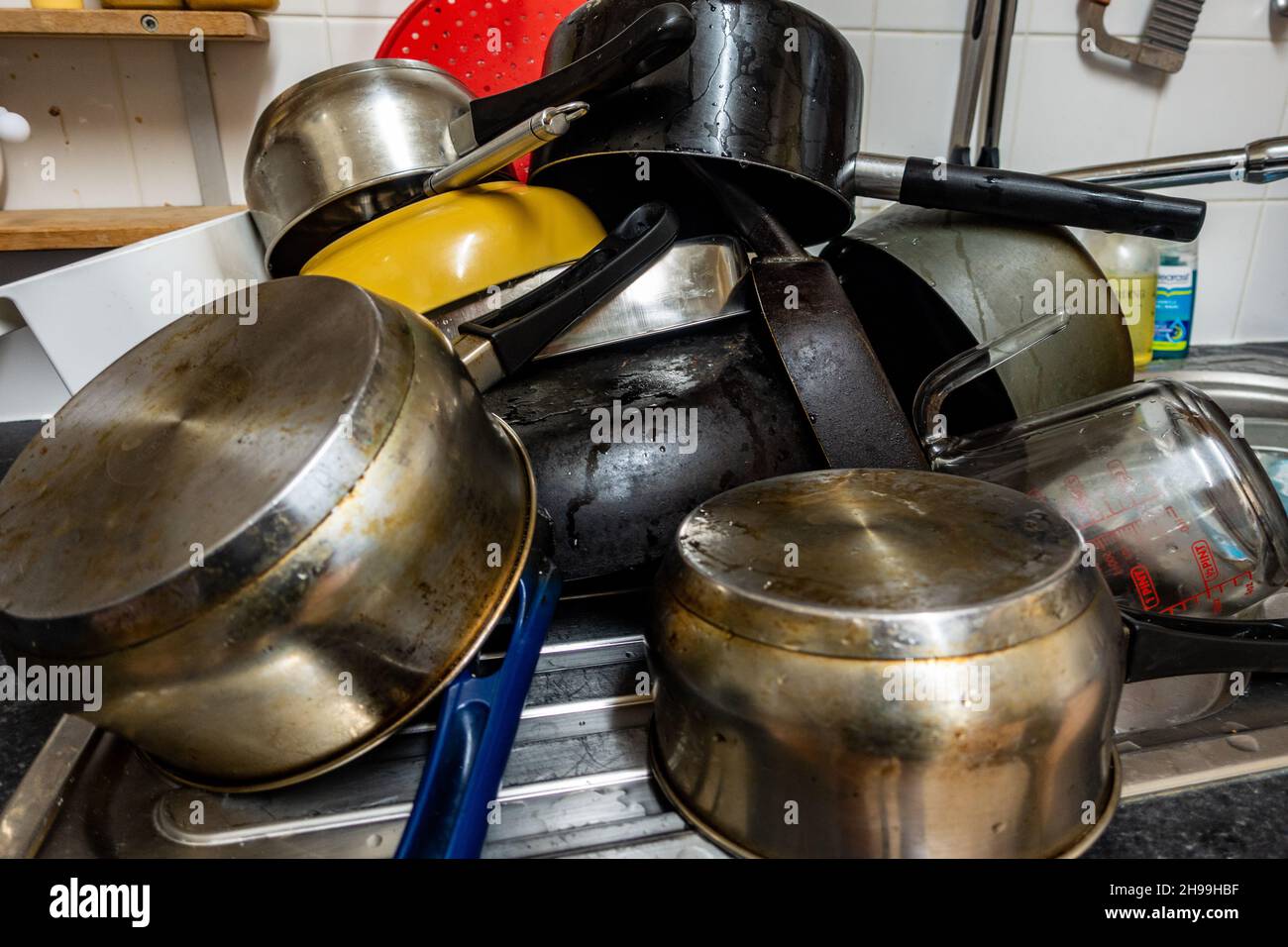 https://c8.alamy.com/comp/2H99HBF/big-pile-of-upside-down-cooking-pots-and-pans-2H99HBF.jpg