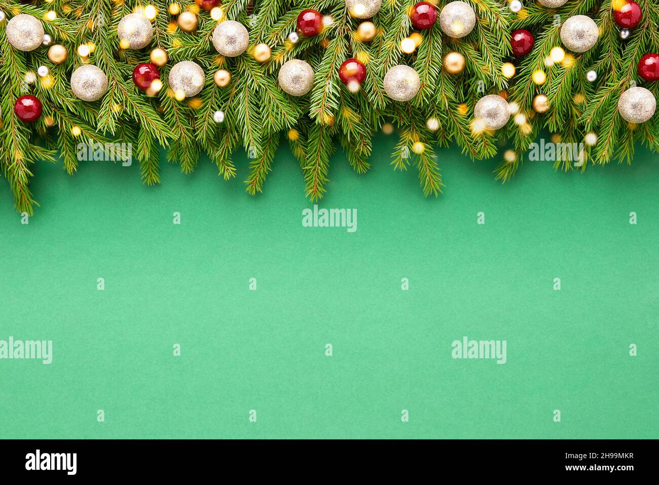 Christmas background. Christmas decoration on fir tree branches on a green background. Top view, copy space for text. Stock Photo