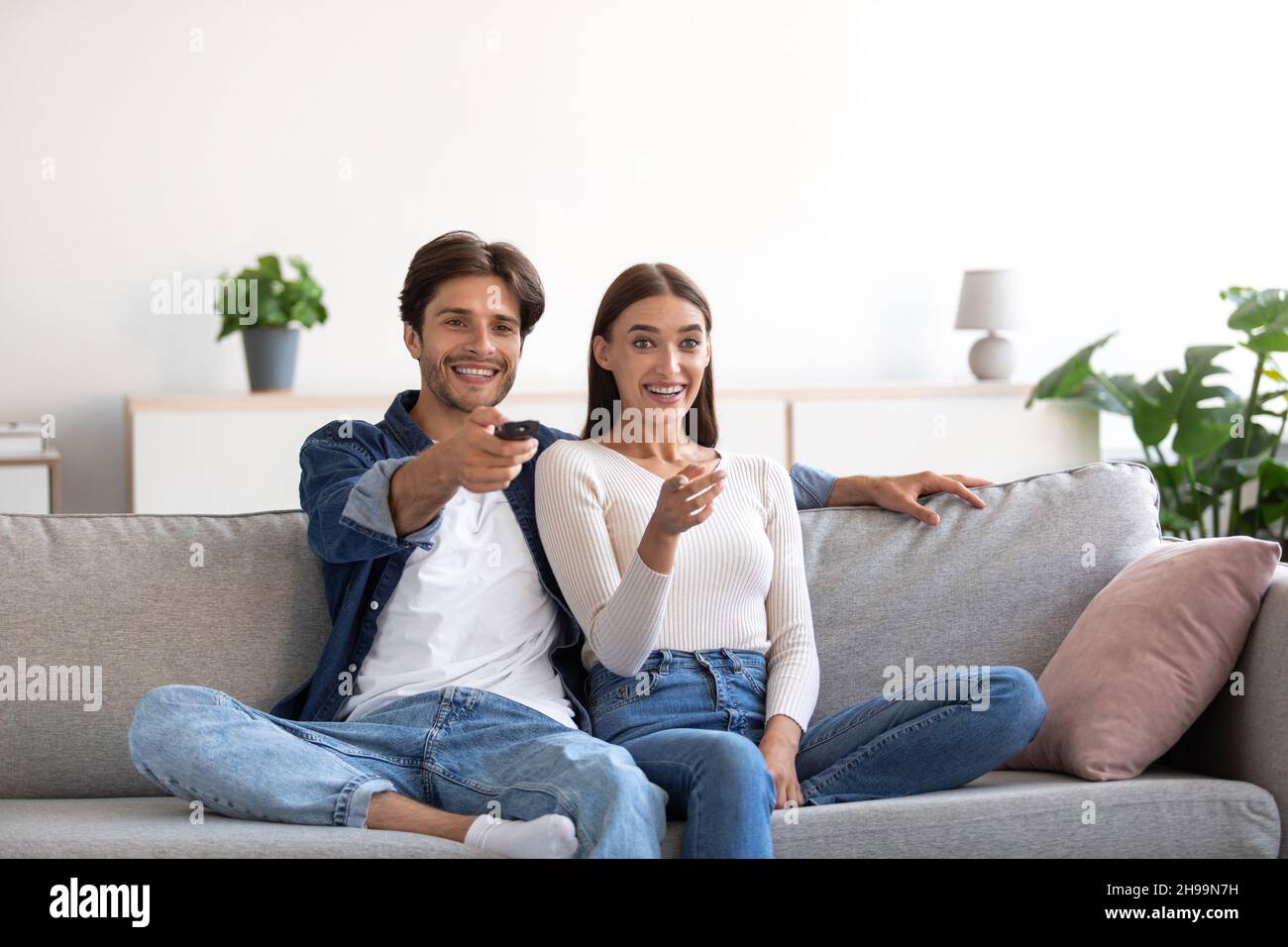 Happy laughing relaxed millennial european woman and man with remote ...
