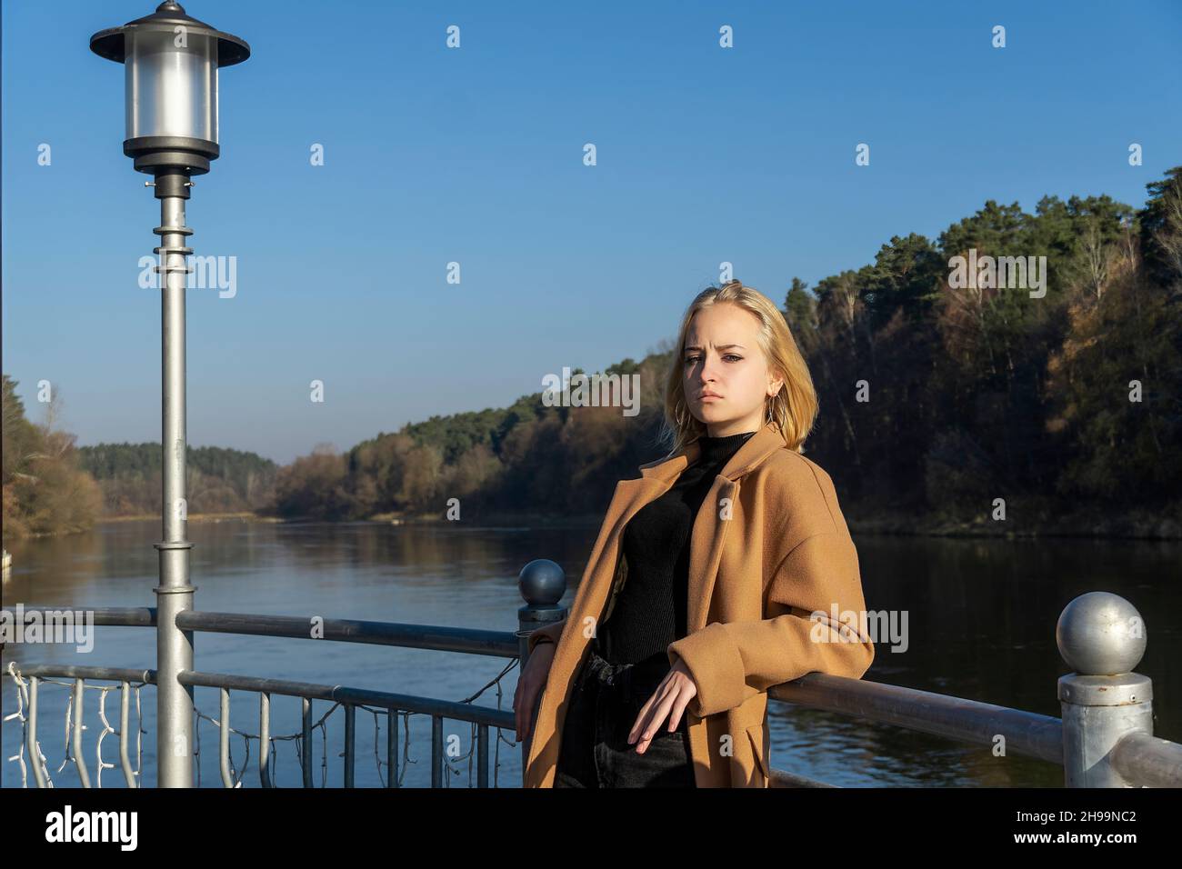 portrait of a teenage girl on the background of the river and autumn ...