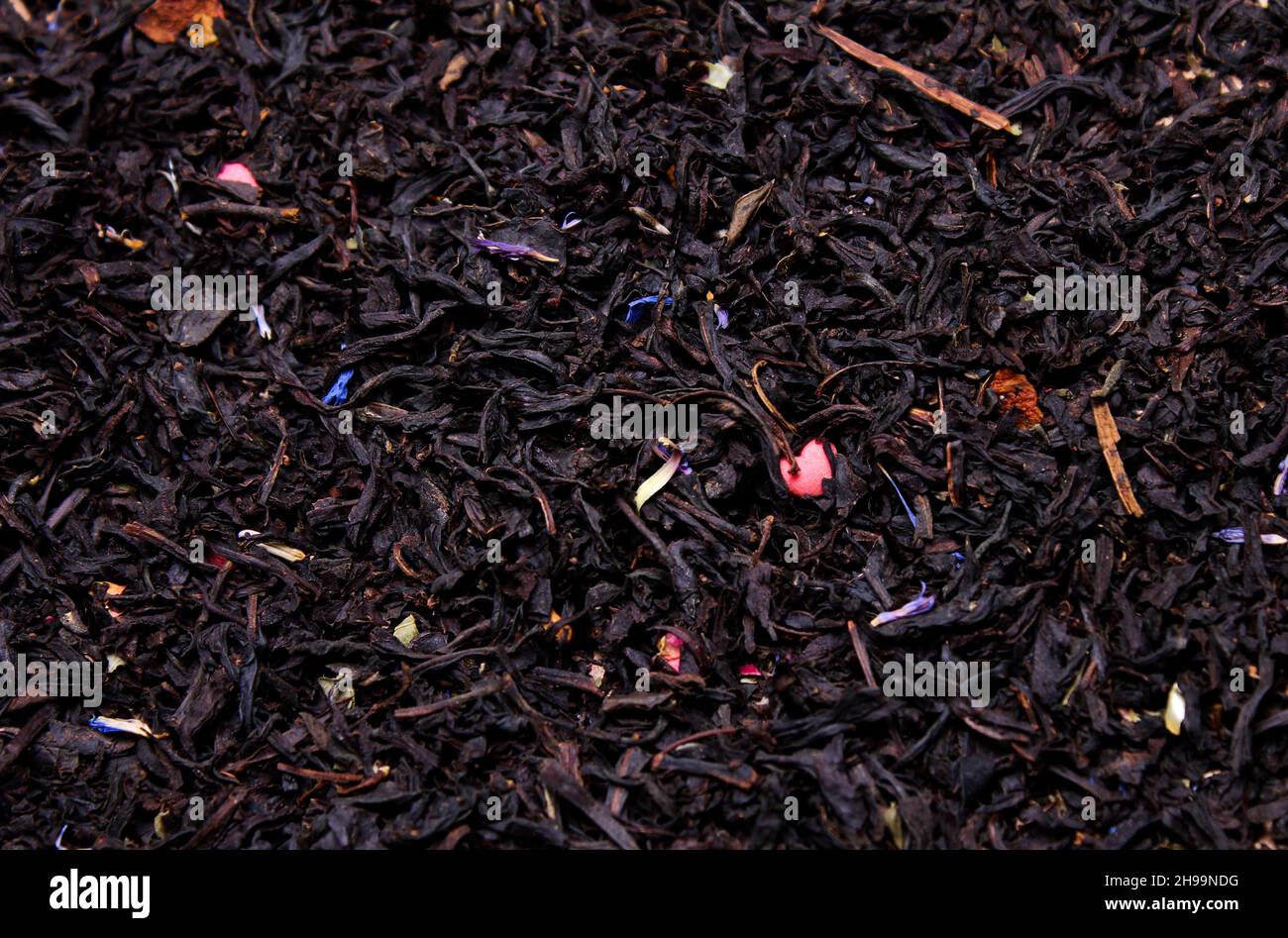 black leaf tea with flower petals close-up, drink Stock Photo