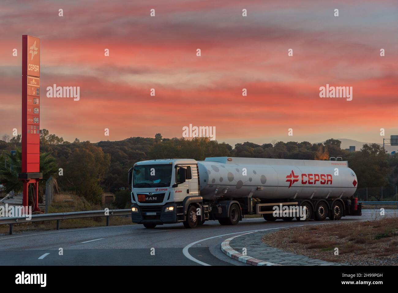 Tanker truck of the oil company Cepsa next to a monolith of a service station at dusk. Stock Photo