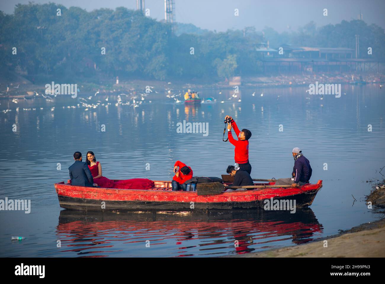 A bride and groom pose for a pre wedding photoshoot on a Boat at Yamuna