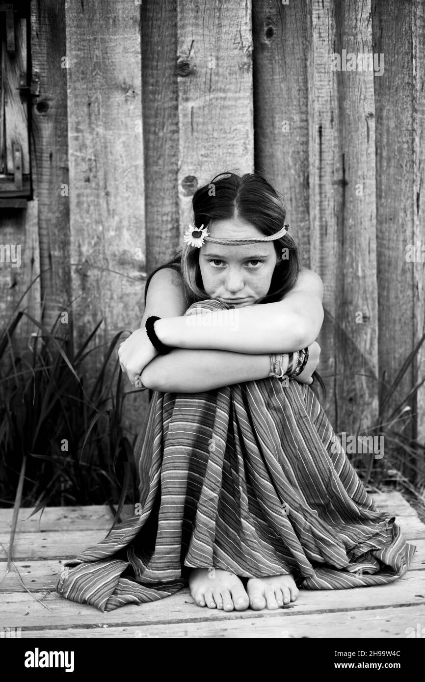 Portraite of country girl sits in the yard of her house. Black and white photo. Stock Photo