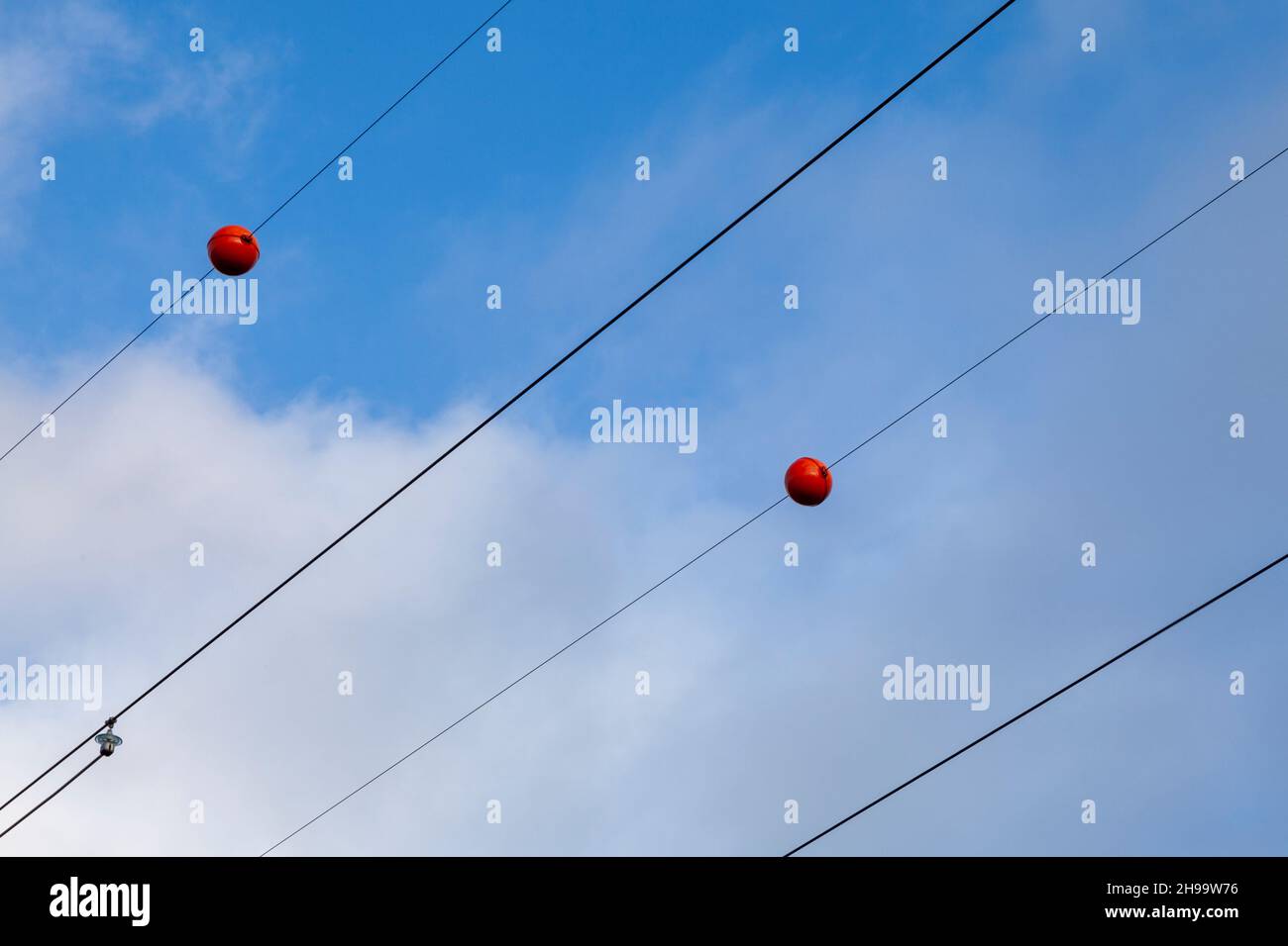 Electric wires with red plastic balls attached to them Stock Photo Alamy