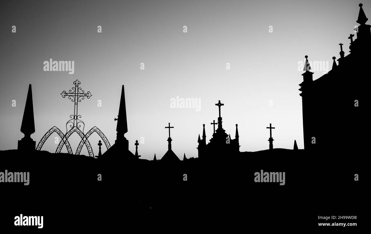 Silhouettes of crosses in a twilight cemetery. Black and white photo. Stock Photo