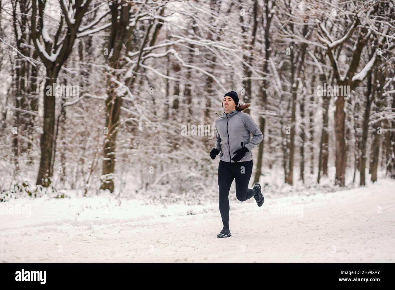 Fast runner running in woods at snowy winter day. Healthy habits ...