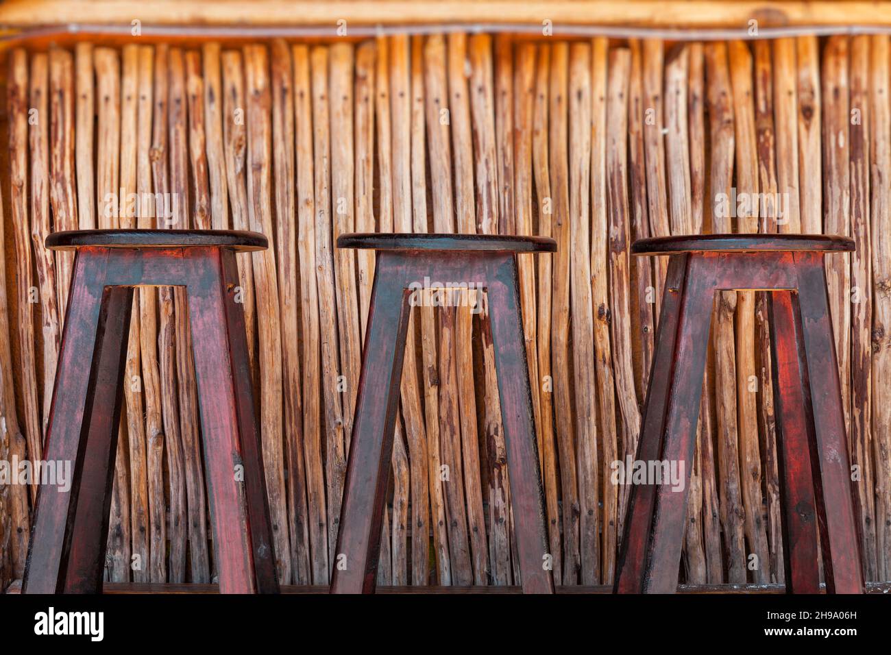 Three bar stools and bar on a beach Stock Photo - Alamy