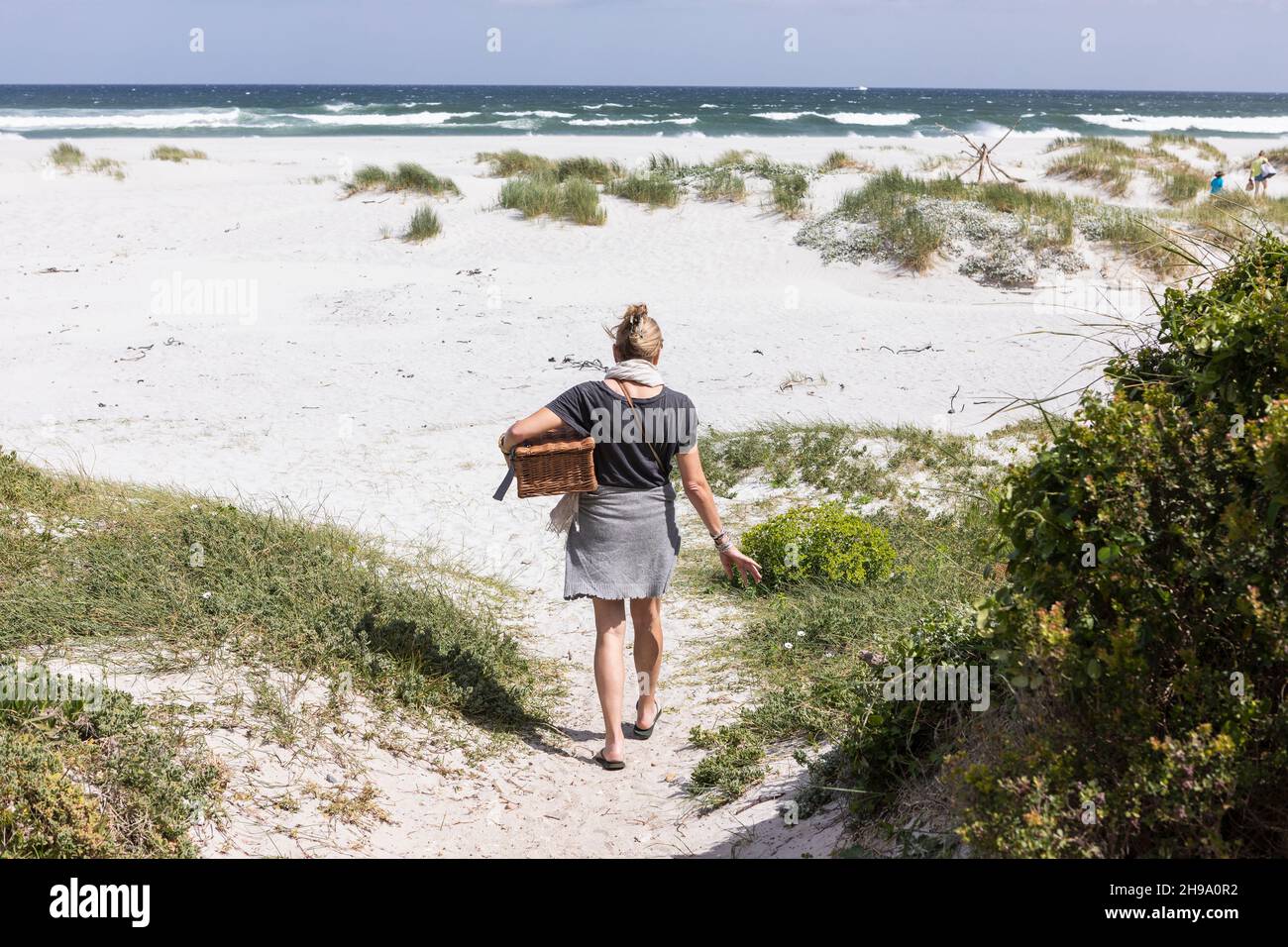 Adult woman carrying picnic basket on Grotto Beach, Hermanus, Western