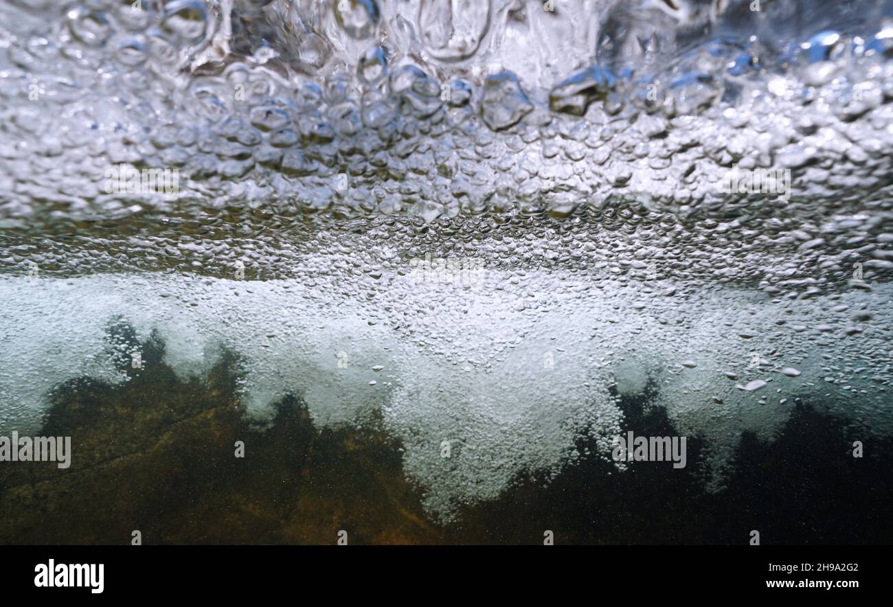 Air bubbles under water surface generated by a waterfall in a river