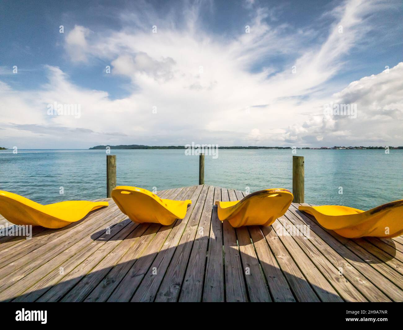 Four yellow deckchairs on a pier in the lake Stock Photo - Alamy