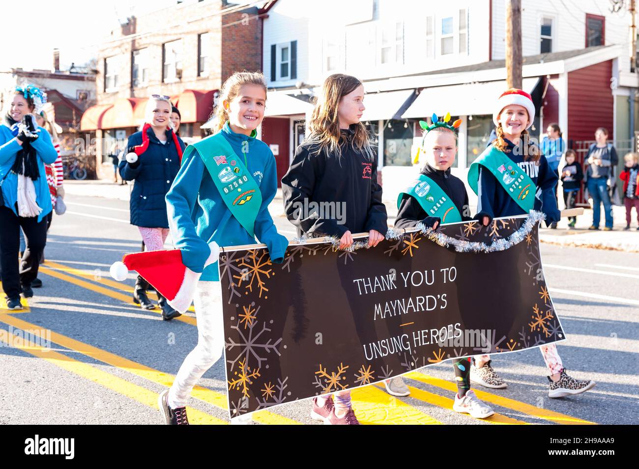 Four young girls carrying a sign saying “Thank You to Maynard’s Unsung
