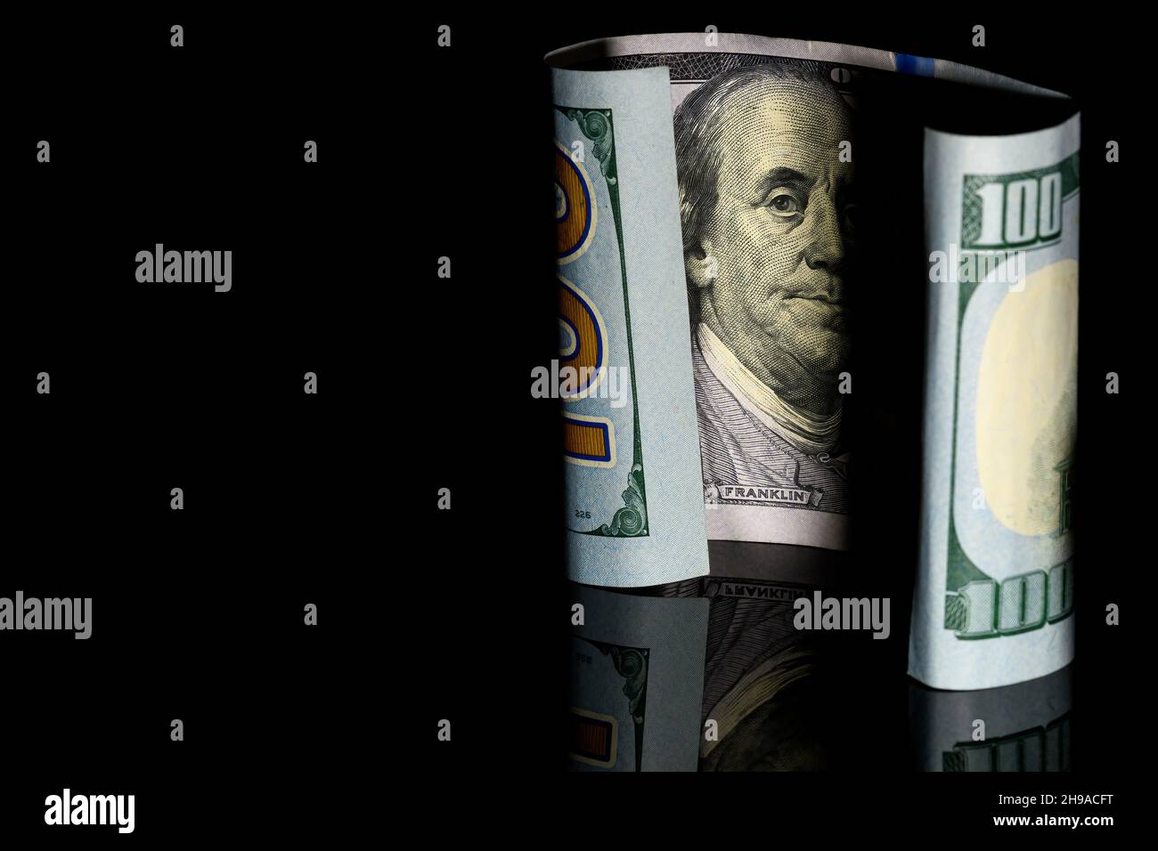 One Hundred Dollar Bill, US, on Black Background with Benjamin Franklin, Copy space on Left Stock Photo