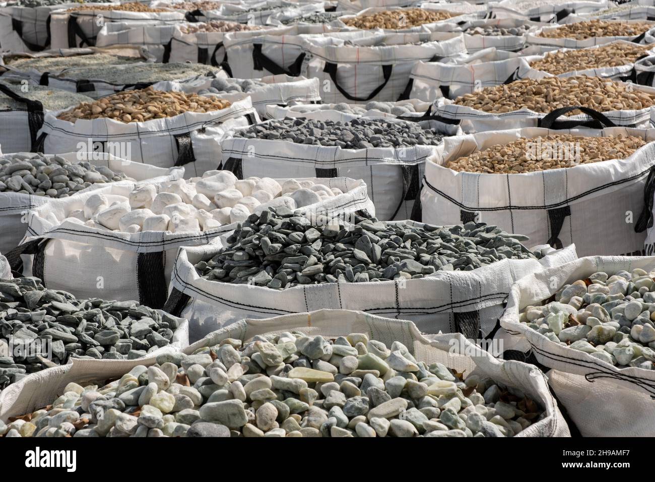 A lot of one cubic meter bags filled with variations of garden decorative crushed stones in the Hardware Store. Stock Photo