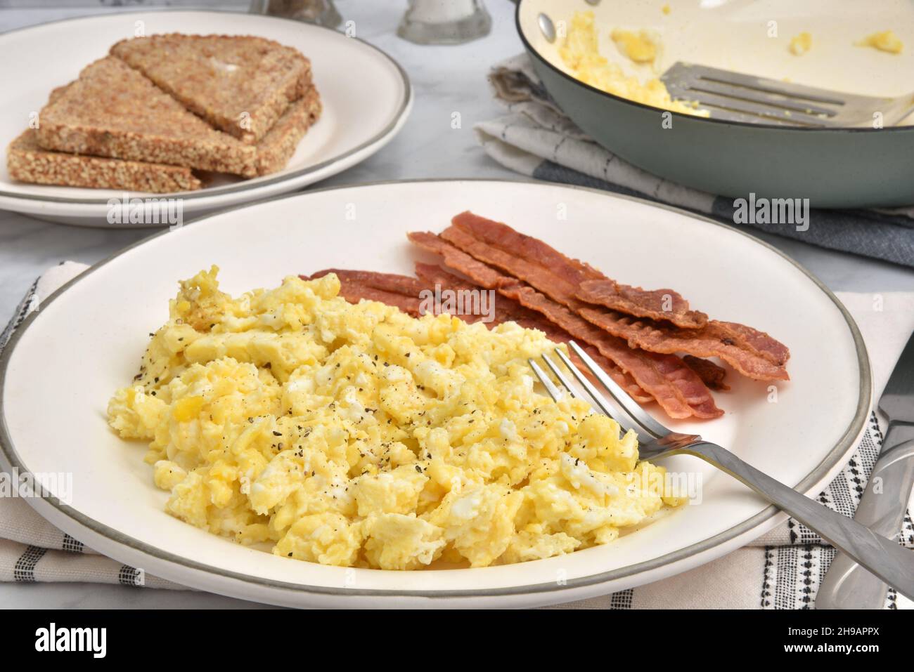 Scrambled egg, bacon and toast breakfast close up Stock Photo