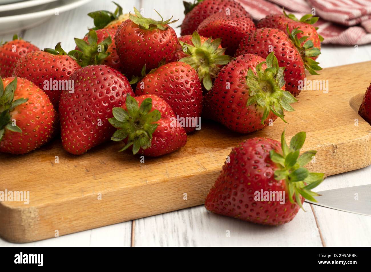 Fresh juicy ripe organic strawberries on a wooden cutting board close up Stock Photo