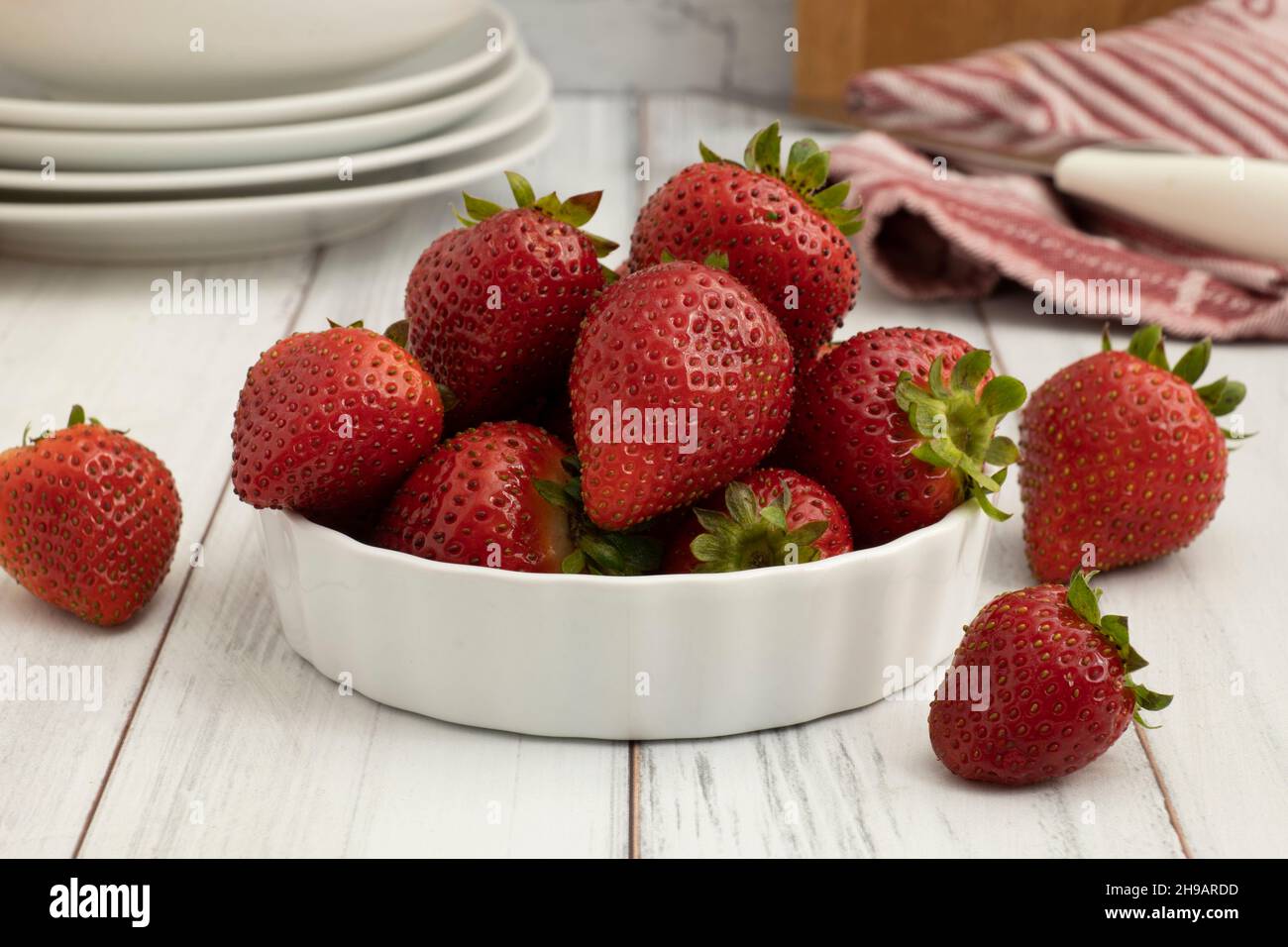 Bowl of fresh ripe strawberries on a wooded table close up Stock Photo