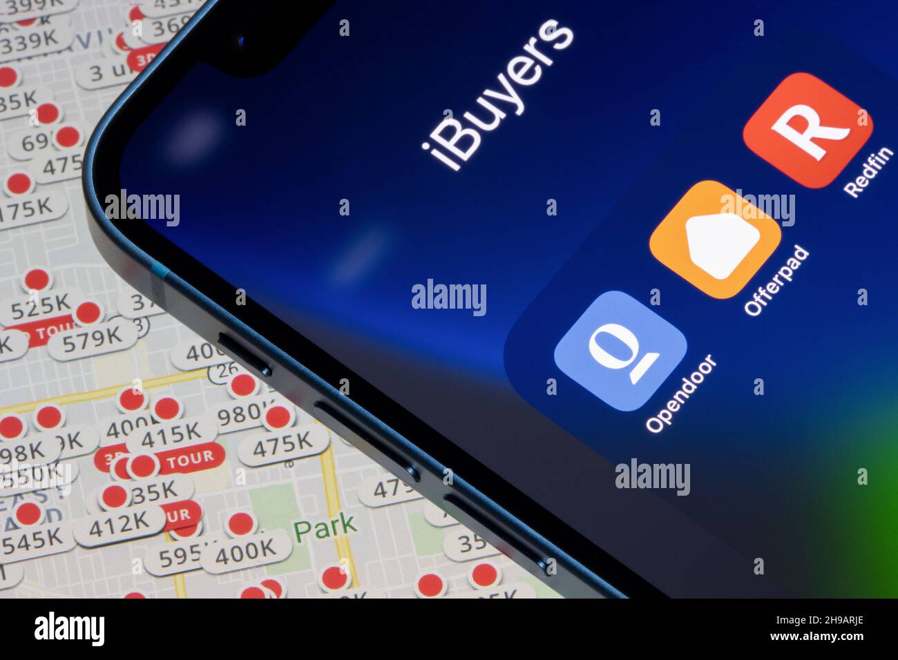 Real estate iBuyers' apps - Opendoor, Offerpad, and Redfin are seen on an iPhone over the Zillow website's listed properties map in Portland, Oregon. Stock Photo