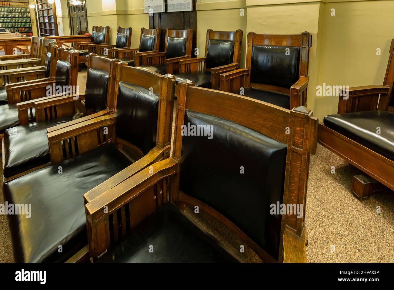 Classic leather and oak jury chairs in jury box of a courtroom of the