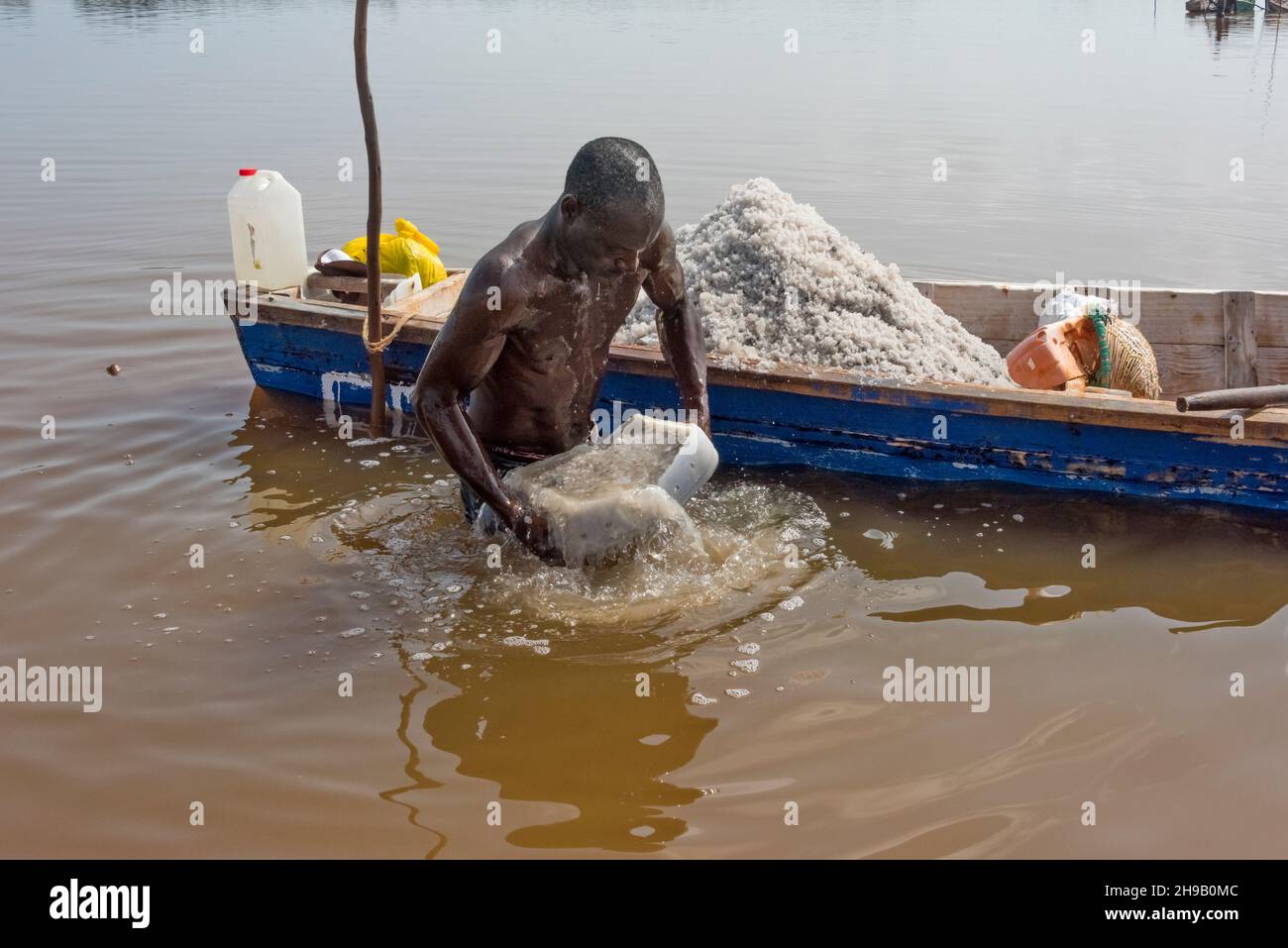 Worker harvesting salt on Lake Retba (Pink Lake), UNESCO World Heritage site, Cap Vert peninsula, Senegal Stock Photo