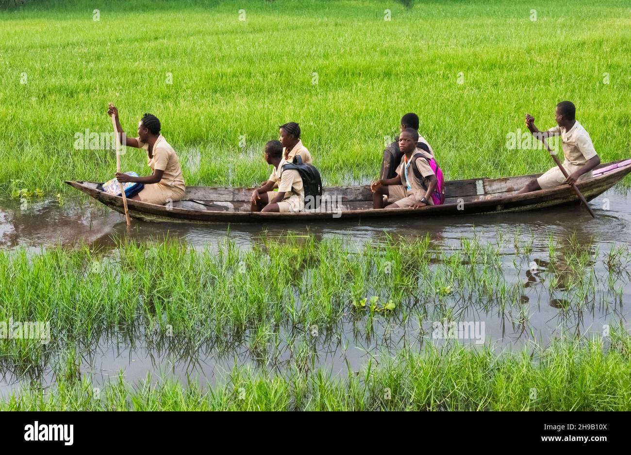 Students traveling on boat to go to school in the lake village of Ganvie on Lake Nokoue, Benin Stock Photo