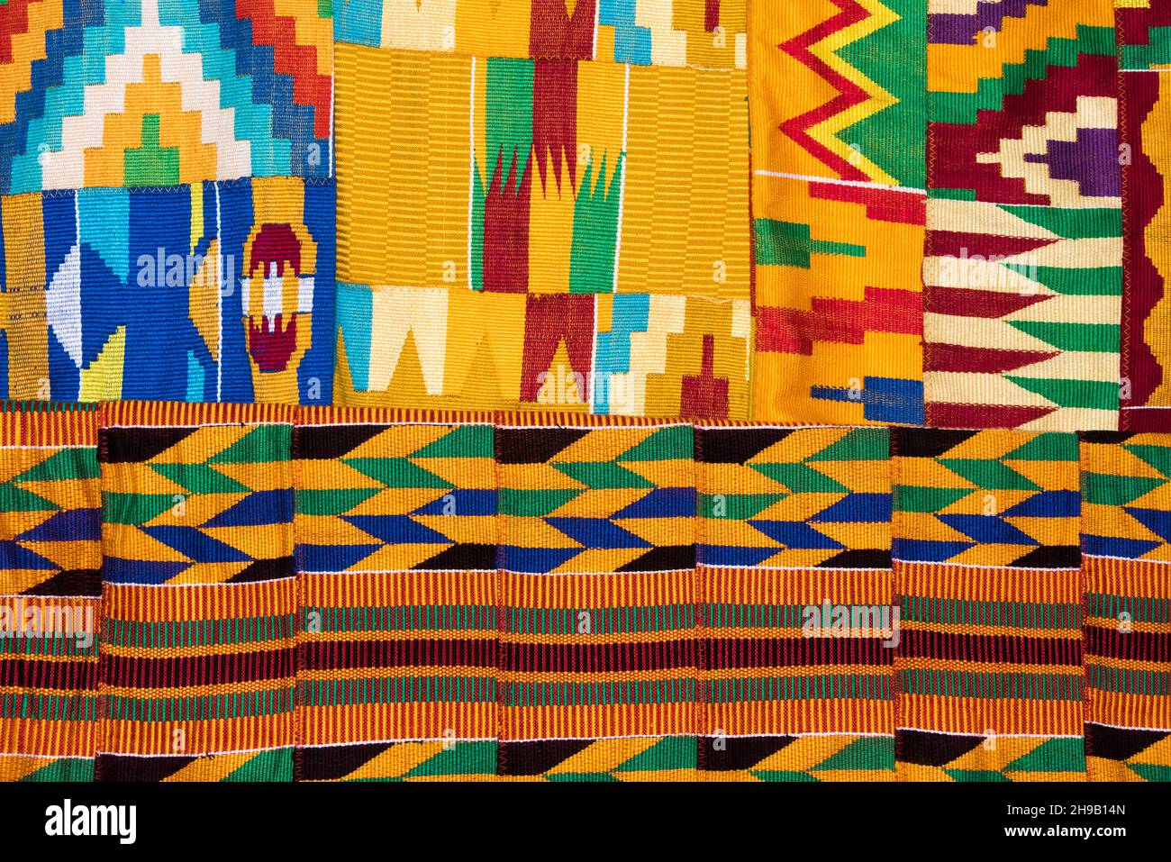 Weaving Kente cloth, a type of silk and cotton fabric made of interwoven cloth strips made and native to the Akan ethnic group of Ghana, Ashanti Regio Stock Photo