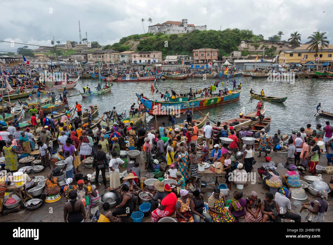 People waiting for the fishing boats to come into the harbor, Elmina, Central Region, Ghana Stock Photo