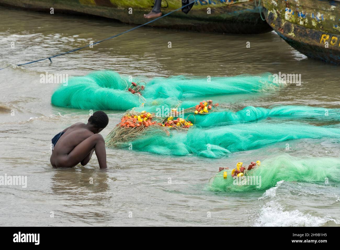 Fisherman and fish net on the beach, Elmina, Central Region, Ghana Stock Photo