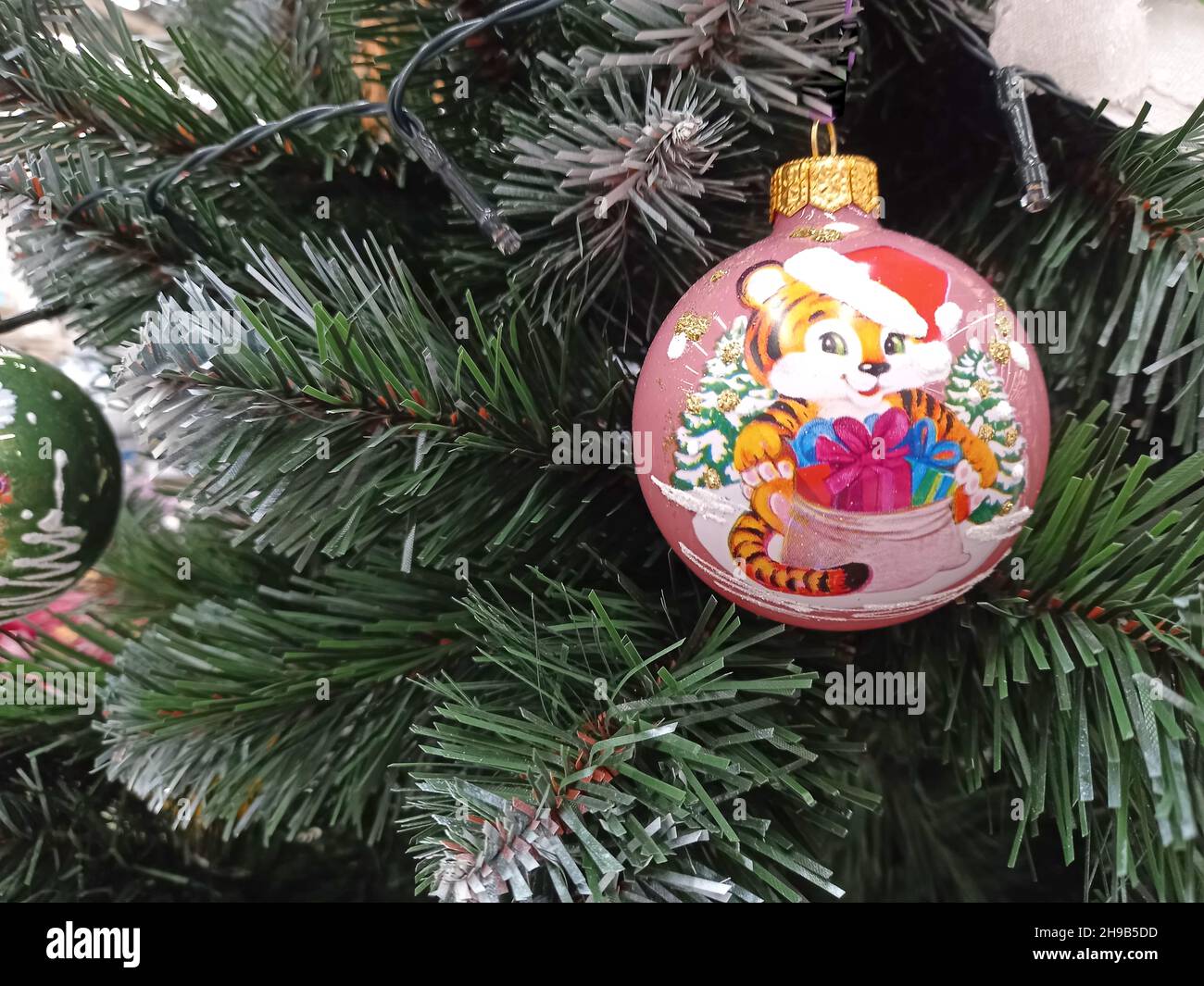 Christmas tree. A beautiful, bright glass ball on the tree. Year of the tiger 2022. Stock Photo