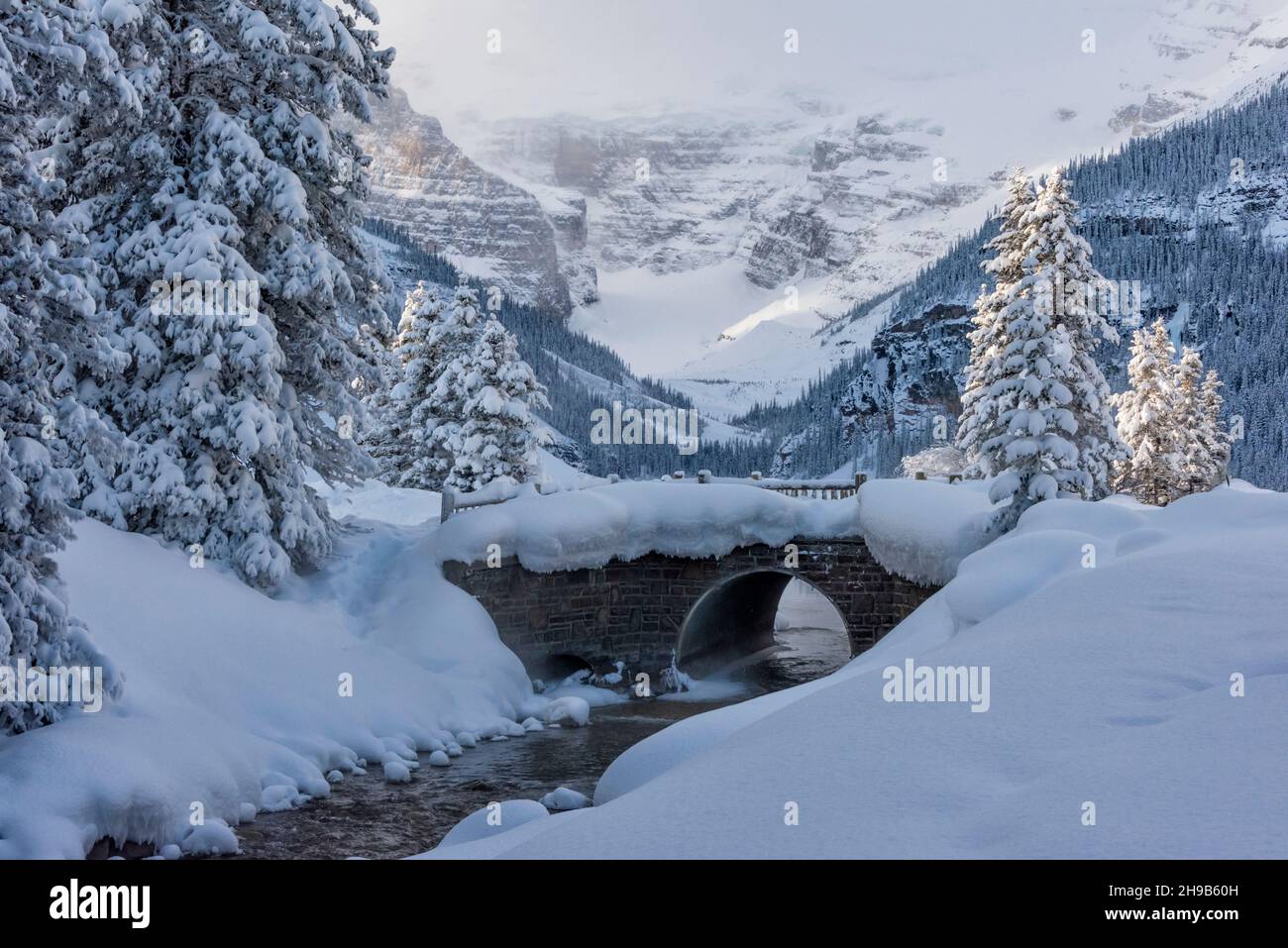Stone bridge over a brook covered with snow, Lake Louise, Banff National Park, Alberta, Canada Stock Photo