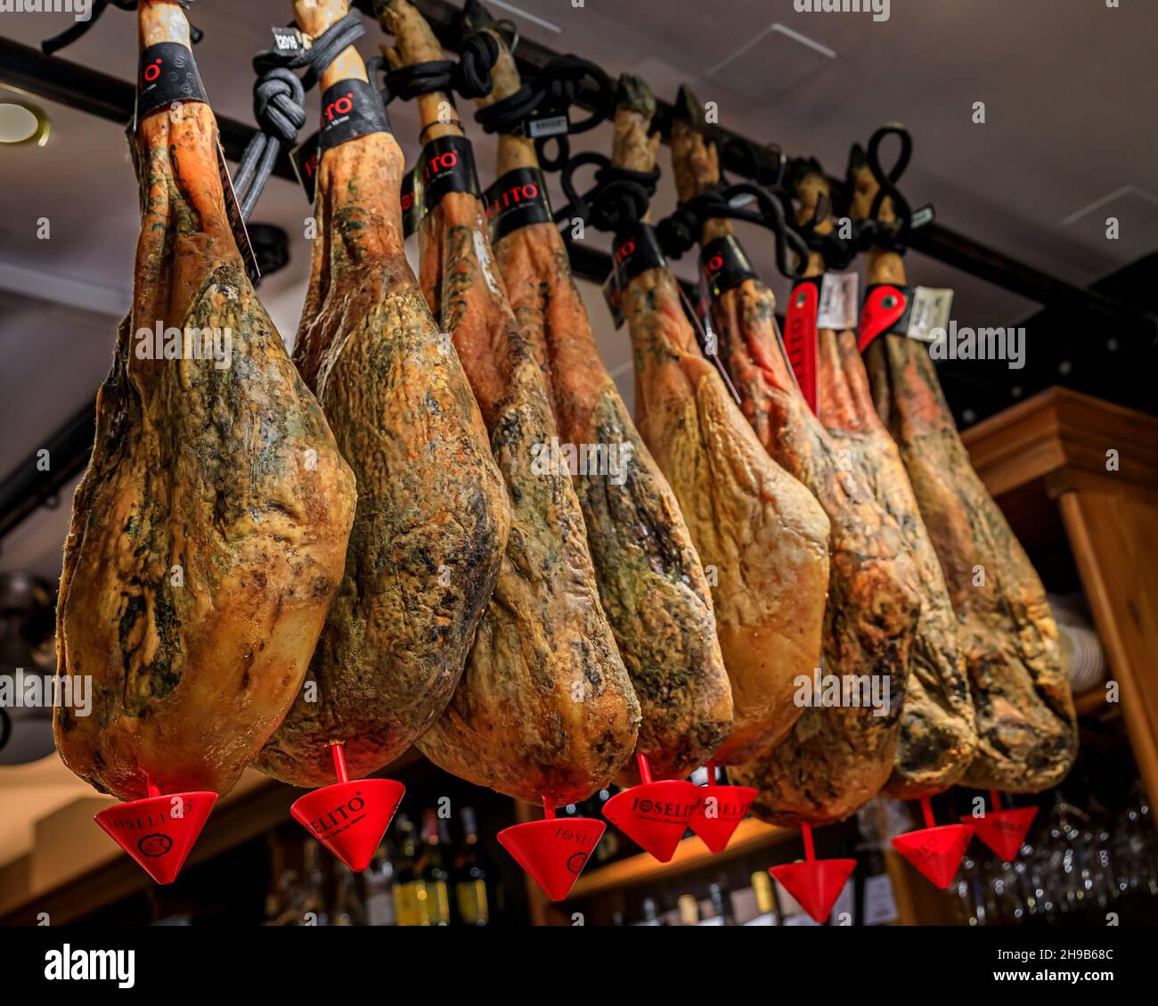 San Sebastian, Spain - June 25, 2021: Whole bone-in legs of Spanish serrano iberico ham on display at a restaurant in Donostia, Basque Country Stock Photo