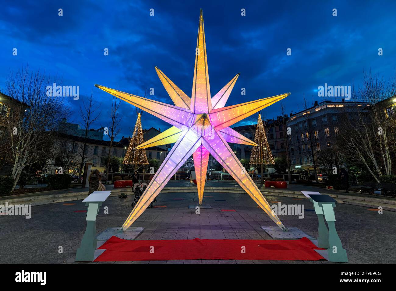 Illuminated Christmas installation on town square in the evening in Alba, Piedmont, Northern Italy. Stock Photo