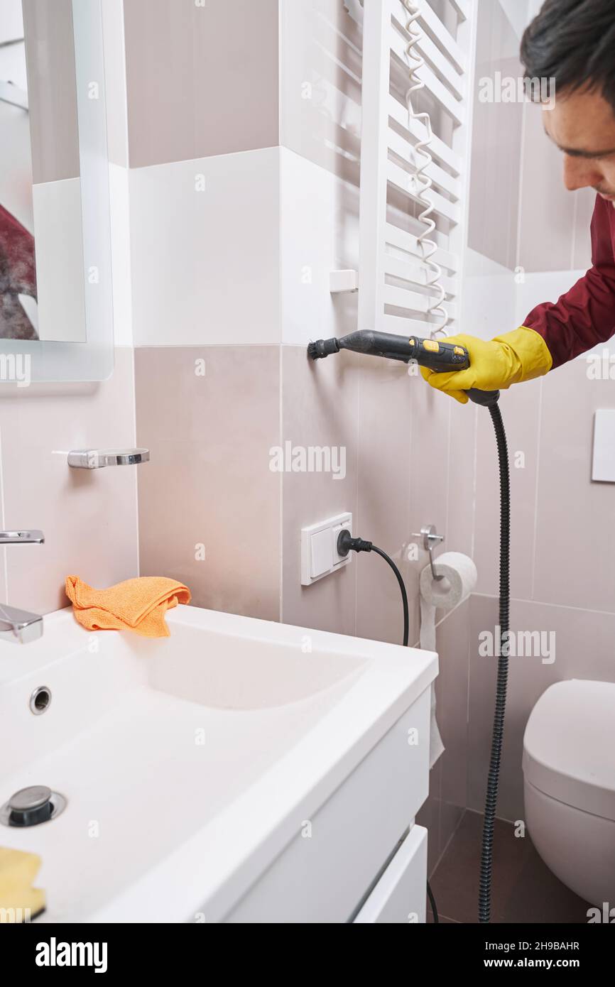 Worker cleaning grout line on wall with steam cleaner Stock Photo Alamy