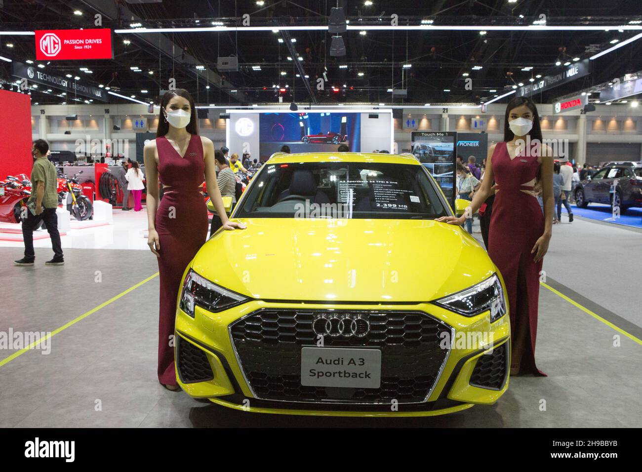 Parkked, Thailand. 04th Dec, 2021. Pretty girl standing next to an Audi car for the photographer to take a photo.The event 'The 38th Motor Expo - Motor Expo 2021' under the concept of 'Happy Motor Vehicles' (TIME to ENJOY!), a meeting place and exchanging opinions of those who love cars This event collects new cars of the year. with full promotions for the end of the year 2021, starting from 1-12 December 2021 at the IMPACT Challenger 1-3 Building, Muang Thong Thani. (Photo by Atiwat Silpamethanont/Pacific Press) Credit: Pacific Press Media Production Corp./Alamy Live News Stock Photo