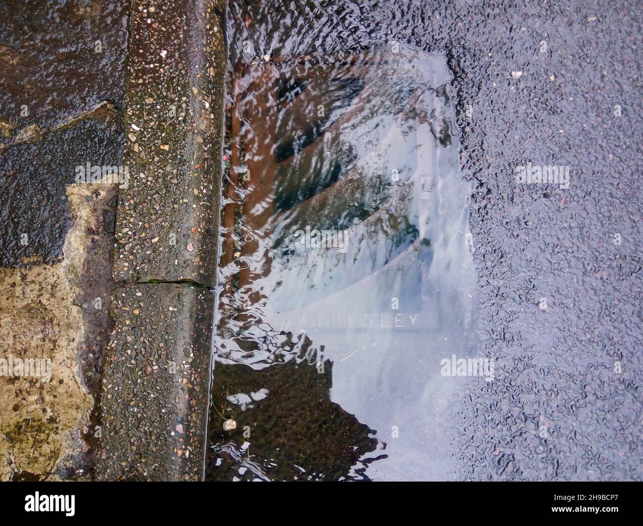 Overflowing drain with run off rain water UK Stock Photo