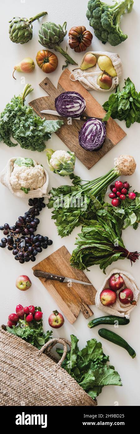 Table with fresh seasonal vegetables, greens, fruit, vertical composition Stock Photo