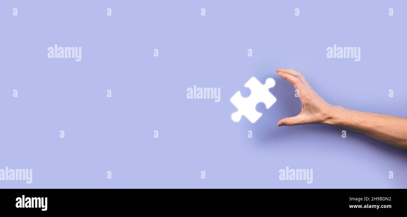 Businessman hands connecting puzzle pieces representing the merging of two companies or joint venture, partnership, Mergers and acquisition concept Stock Photo