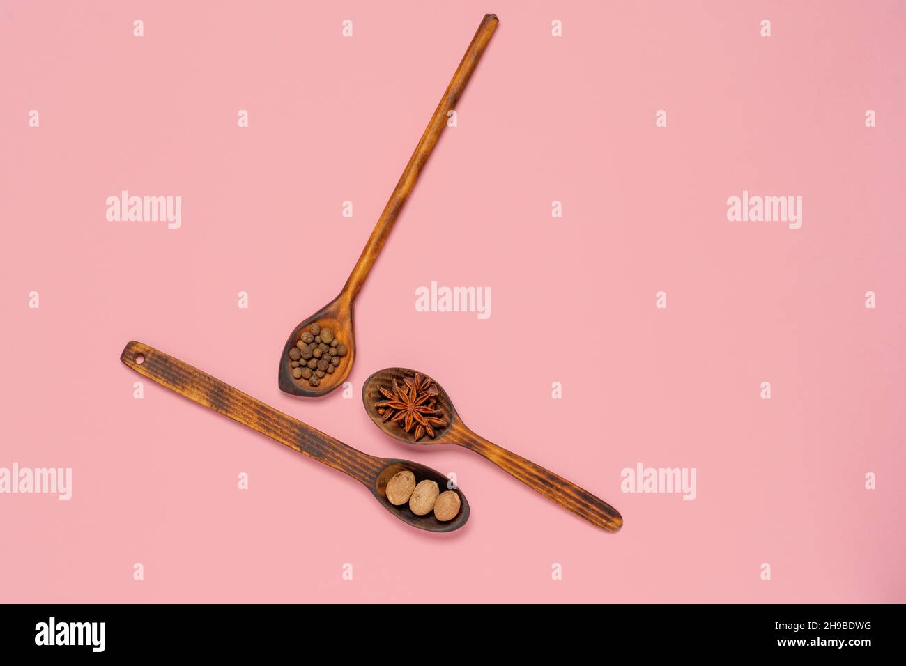 anise star, nutmeg and allspice in spoon on colorful background with copy space. Flat lay background Stock Photo