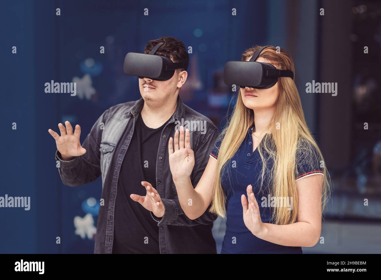 People playing new virtual games on metaverse blockchain technology with vr goggles Stock Photo