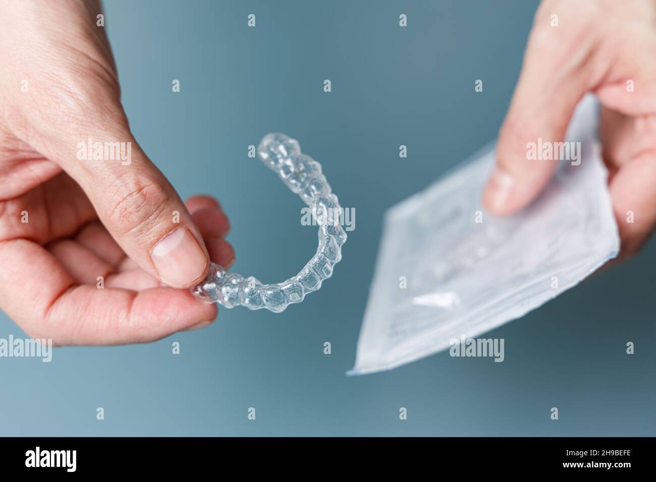 Man holding transparent aligner and its package. Invisalign ...