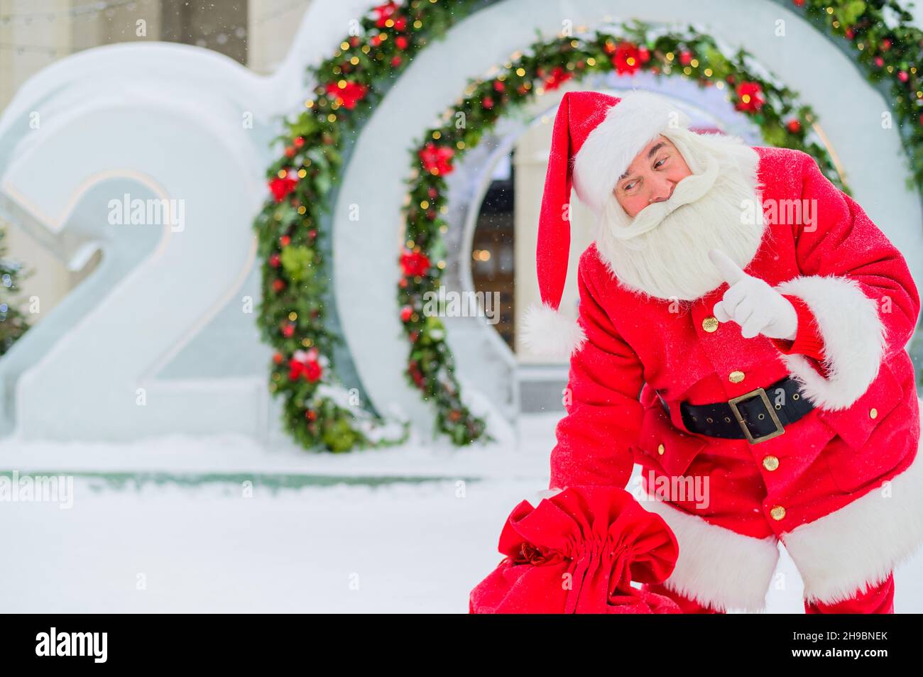 Santa Claus posing with a bag of gifts on the background of Christmas ...