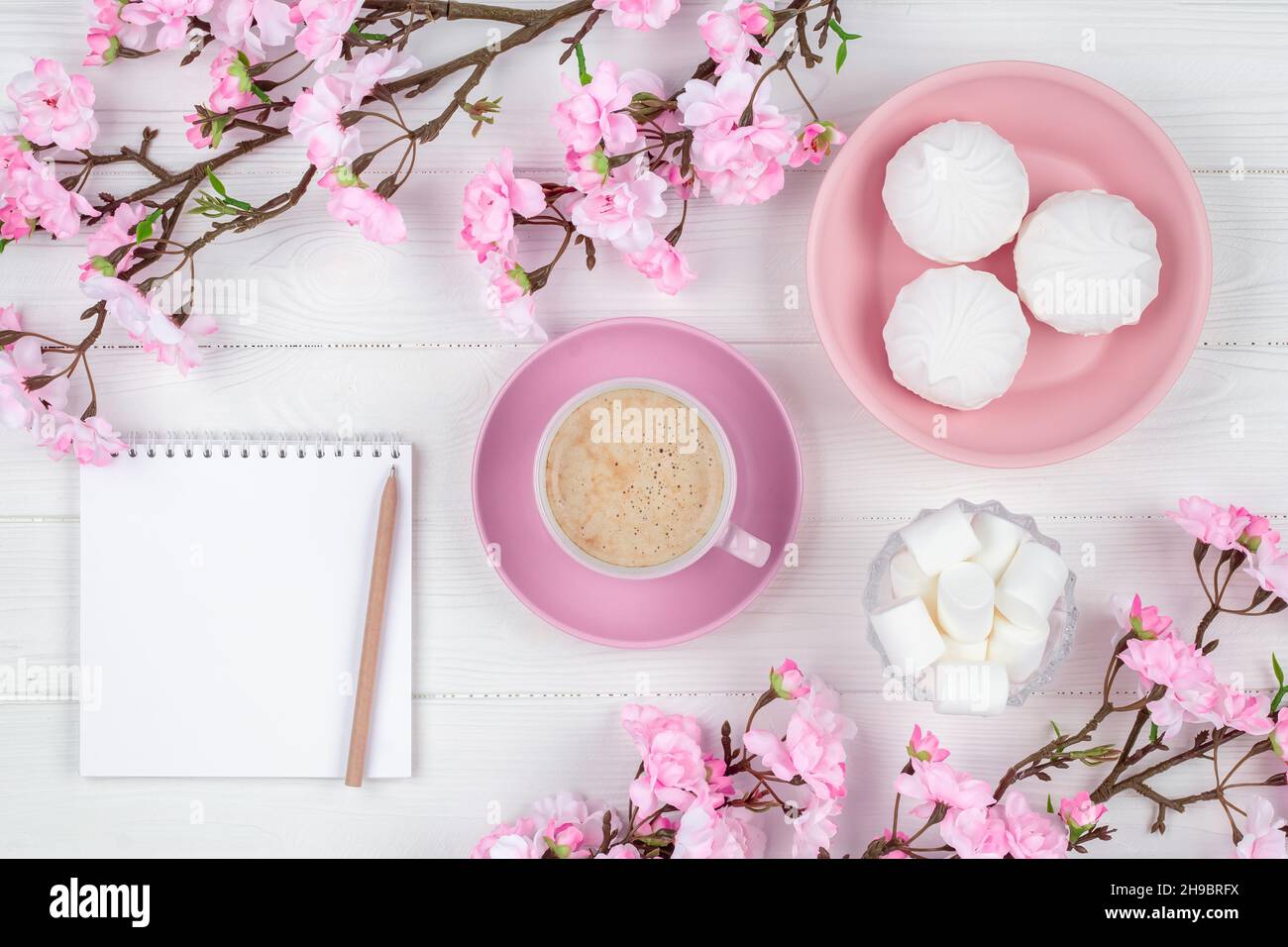 Coffee cup with marshmallow in the morning for breakfast. Blank notebook with pen. Diary, planning concept. Romantic spring mockup with copy space. Ch Stock Photo