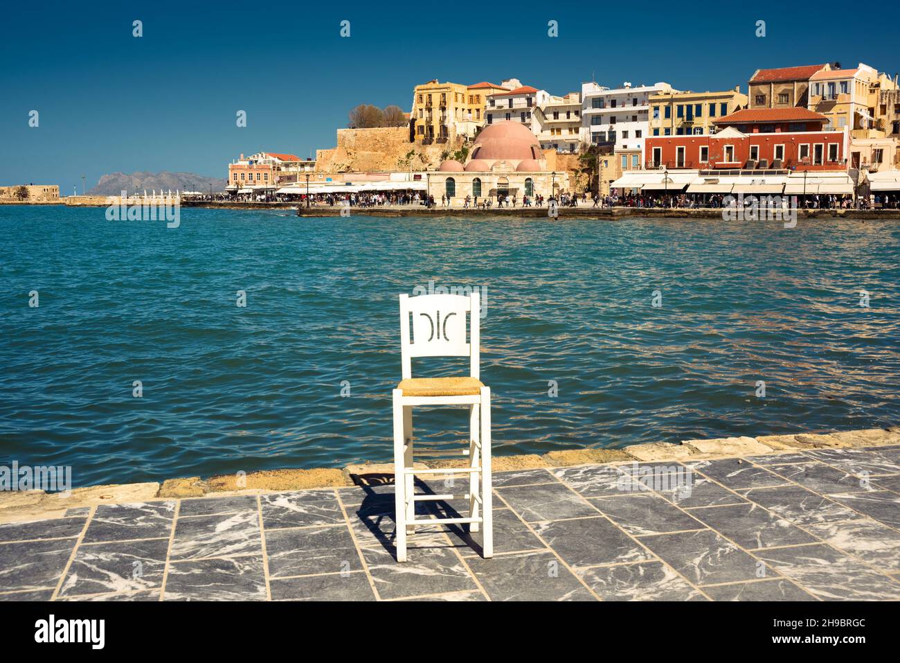 White chair on a seafront. Old city of Chania, Crete Stock Photo