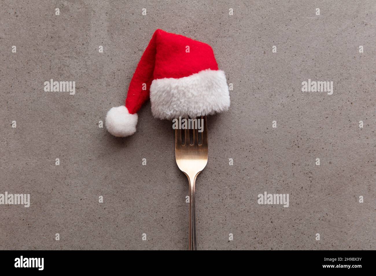 Christmas food background. Fork utensil wearing a festive father Christmas hat Stock Photo