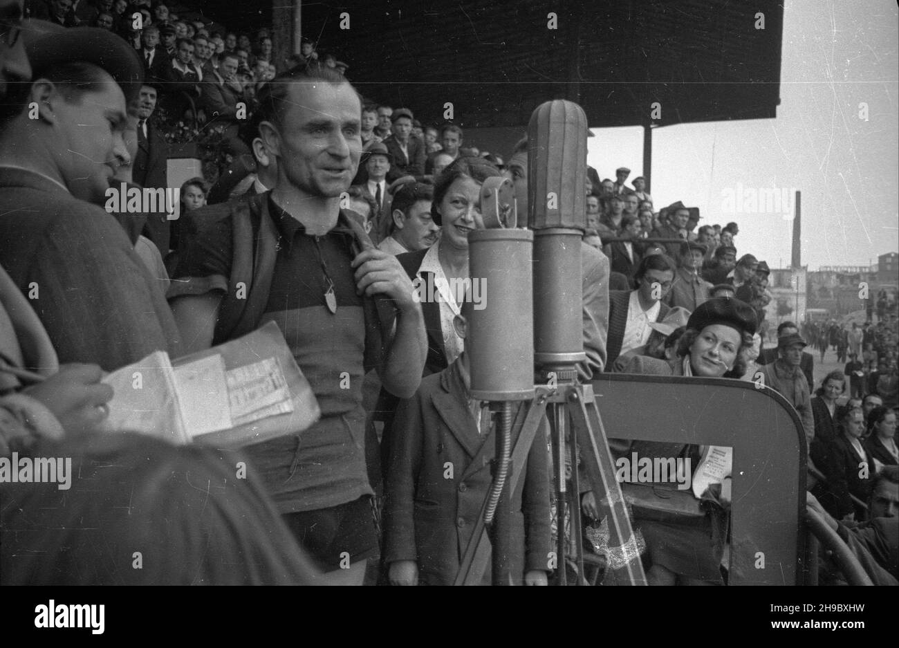 Warszawa, 1947-09-28. Stadion wojskowego Klubu Sportowego Legia. Pierwszy powojenny Wyœcig Kolarski Dooko³a Polski na trasie Kraków-Warszawa (VI Tour de Pologne). Nz. przed mikrofonem kolarz Marian RzeŸnicki (zwyciêzca etapu II Bytom-Czêstochowa oraz zdobywca czwartego miejsca na etapie £ódŸ-Warszawa). Z lewej sprawozdawca sportowy Polskiego Radia Józef Ma³gorzewski. bk/ppr  PAP      Warsaw, Sept. 28, 1947. Stadium of the Legia military sports club. The first cycling race around Poland after the war (VI Tour de Pologne) from Cracow to Warsaw. Pictured: talking into microphone cyclist Marian Rz Stock Photo