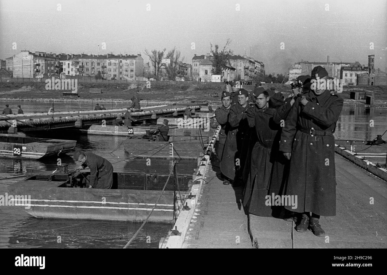 Warszawa, 1947-10. Most tymczasowy, most p³ywaj¹cy - pontonowy w pobli¿u zniszczonego Mostu Kierbedzia. Nz. ¿o³nierze rozk³adaj¹ fragment mostu, by umo¿liwiæ przejazd barki. W g³êbi zabudowania na praskim brzegu Wis³y. ps/gr  PAP    Dok³adny dzieñ wydarzenia nieustalony.      Warsaw, Oct. 1947. A pontoon bridge near the damaged Kierbedz Bridge. Pictured: soldiers disassemblying a fragment of the bridge to allow a barge to pass. In the background buildings of Warsaw's Praga district.  ps/gr  PAP Stock Photo